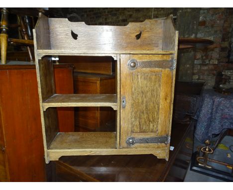 An Edwardian oak Wall Bracket with open shelves and cupboard, with strapwork hinges of Art Nouveau design.  22" (56cms) wide.