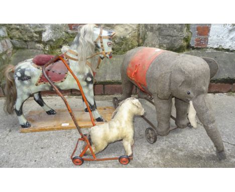 A wheeled Elephant push along Toy, 21" (53cms) long, a Chiltern push toy dog and a dapple grey toy horse on a wooden stand, 2