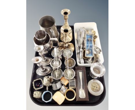 A tray of silver plated and other metal wares, set of six egg cups, two pairs of candlesticks, napkin rings, loose flatware e