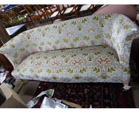Early 20th century three-seater floral upholstered sofa raised on short turned wooden legs with casters, 180cm wide