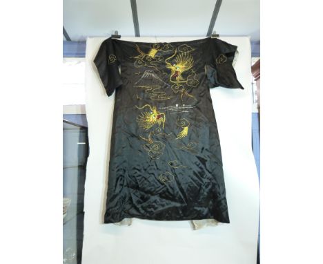 Oriental jacket, the black silk crowned with embroidered dragons in gilt chasing the flaming pearl