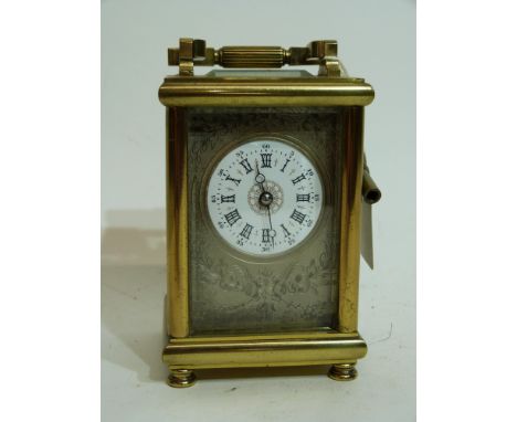 Late 19th century carriage clock with white enamel dial, Roman numerals, surrounded by chased silver metal case