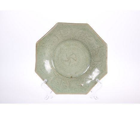 A CHINESE LONGQUAN CELADON OCTAGONAL STONEWARE DISH, possibly Yuan/Ming Dynasty, with incised scroll decoration. 19.5cm