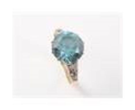 A BLUE ZIRCON SET RING, the round cut blue zircon claw set in a pierced mount between pierced tapering shoulders each set wit