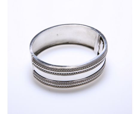 A VICTORIAN SILVER BANGLE, BIRMINGHAM 1882, hinged, one half in relief with geometric bands. Internal width 61mm, 1.2 troy ou