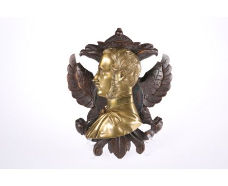 A MID 19TH CENTURY BRASS PORTRAIT RELIEF OF PRINCE ALBERT, mounted on a carved double headed eagle backboard. Overall 30cm by