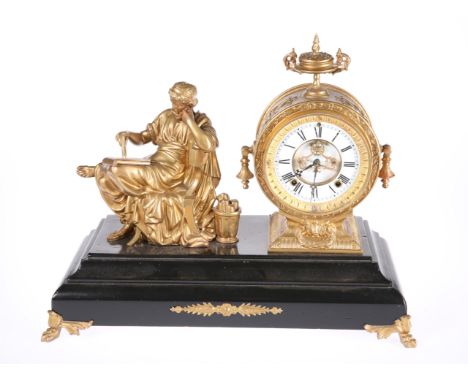 A GILT-METAL MANTEL CLOCK, C.1900, the drum shaped case with urn surmount and pear-drops to either side, the white enamel cha