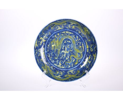 A CHINESE SU-SANCAI DRAGON DISH, glazed in blue, green and yellow with dragons to the well and sides, underglaze blue seal ma