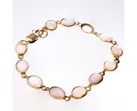 AN 18CT YELLOW GOLD AND OPAL BRACELET, the twelve oval opals (one lacking) set on articulated links on lobster catch. Stamped