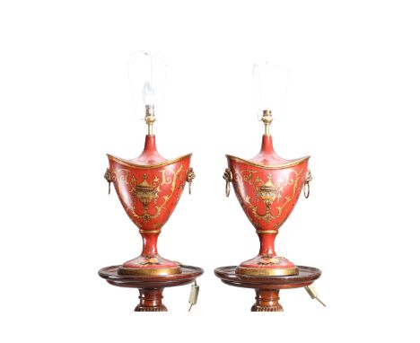 A PAIR OF RED "TOLE" TABLE LAMPS, of urn form, decorated with urns and foliage. 63cm to top of shade fitting