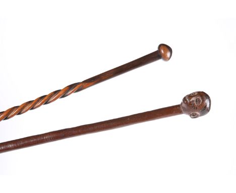 A TRIBAL KNOBKERRIE AND ANOTHER TRIBAL STICK WITH HEAD CARVED HANDLE. (2)