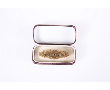A LATE VICTORIAN 9ct GOLD BROOCH, of lozenge form, set to the centre with a small round-cut ruby flanked by twin groups of th
