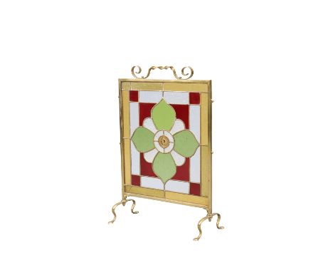AN EDWARDIAN BRASS, LEADED AND STAINED GLASS FIRESCREEN, with large flowerhead to the centre and whiplash cast feet.