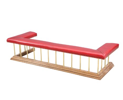 A HANDSOME LEATHER, OAK AND BRASS CLUB FENDER, the upholstered seat raised on reeded columns issuing from an oak kerb. 185cm 