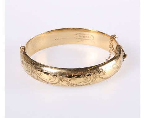A LATE VICTORIAN GOLD-PLATED BANGLE, hinged, one half with foliate engraving, stamped marks. Internal diameter 57mm