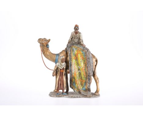 AN EARLY 20TH CENTURY PAINTED SPELTER TABLE LIGHTER, in the form of a rug seller on the back of a camel. 18.5cm high