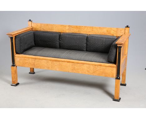 A BIEDERMEIER SATIN BIRCH AND EBONISED SOFA, 19TH CENTURY,&nbsp;with panelled back and sides above an overstuffed seat and pl