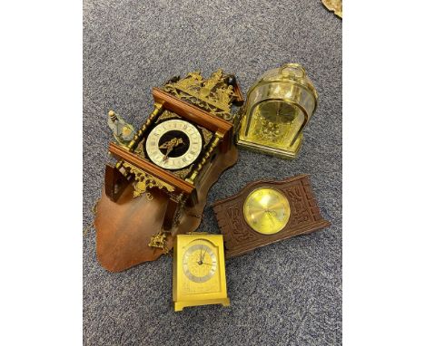 A German style wall clock with various mantel clocks. 