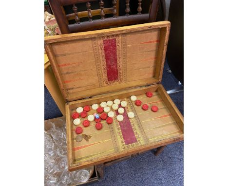 A 19th century backgammon board and checkers. 