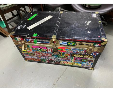 A Vintage travel trunk designed with a large collection of stickers from around the world. 