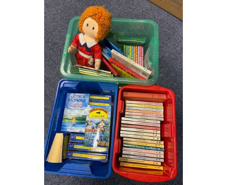 Three boxes of various children's books which includes Enid Blyton novels, Arthur Ransome novels and a vintage Annie doll. 