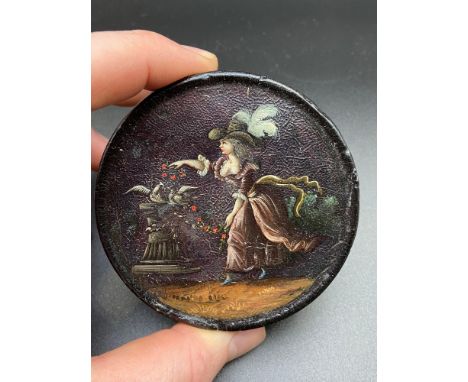 A 19th century paper mache hand painted snuff box. The lid depicts a lady feeding doves. [8cm in diameter] 