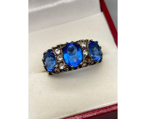 A Gold ladies ring set with three large blue stones and various clear stones. [one missing] [unmarked, tested for 9ct] [Ring 