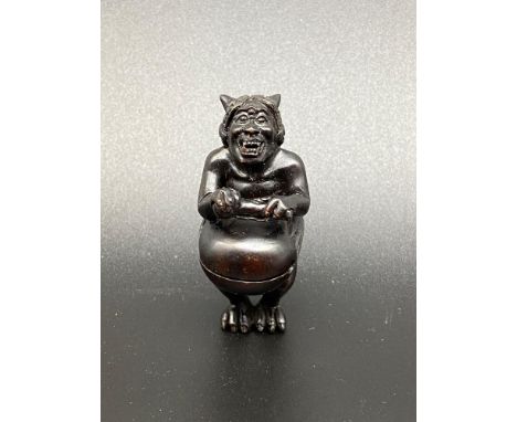A Japanese hand carved netsuke of an Oni Monster. Signed. [5.5cm in length] 