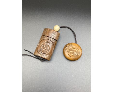 A Japanese hand carved inro. Designed with a ball bead and a snake design Manju Netsuke disc. Signed by the artist. 