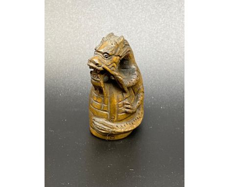 A Japanese hand carved netsuke of a dragon wrapped around a bell. [5cm in length] 