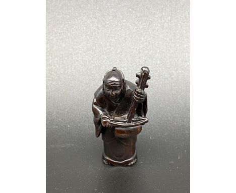 A Japanese hand carved netsuke of a musician, [5cm in length] 