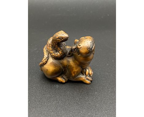 A Japanese hand carved netsuke of a hippo with a snake on its back. [4cm in length] 