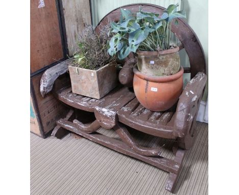 A novelty painted wooden two person bench formed from a vintage cart wheel