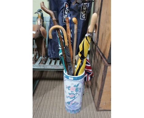 Oriental design ceramic cylindrical stick stand containing s election of sticks and brollies