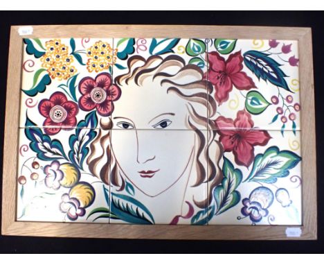 A POOLE POTTERY TILE PANEL, PAINTED BY S.M. POTTINGER after Olive Bourne, a face amongst flowers, framed 34 x 49.5cm