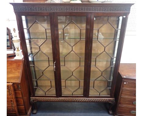 A CHIPPENDALE REVIVAL GLAZED DISPLAY CABINET with three glass shelves and three astragal glazed doors with blind fret frieze 