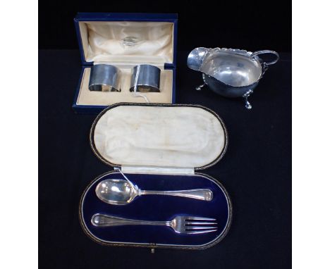 A SILVER CHRISTENING SPOON AND FORK (cased), a silver sauceboat, and a pair of cased napkin rings (rubbed)