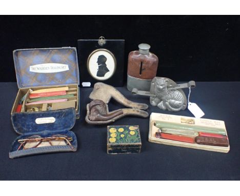 A TINPLATE CAT CONFECTIONARY MOULD 9.5cm high, a framed Silhouette, a pipe carved as an African, and other small collectibles