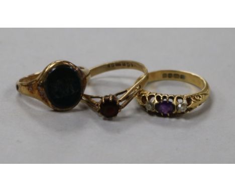 A George V amethyst and diamond three stone ring and two other rings including a bloodstone signet ring with monogram.