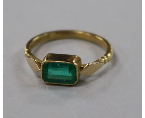 A late 1930's 18ct gold and collet set emerald ring, size K.