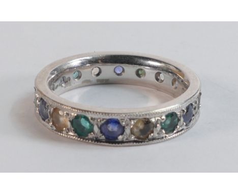 18ct hallmarked white gold full eternity gemstone set ring size R.  Set sapphires, emeralds &amp; others.  Weight 8.1g. 