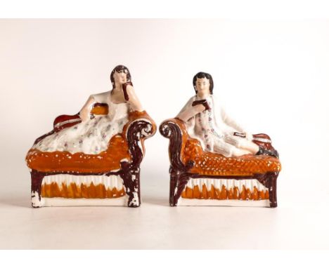 A Pair of mid-late Victorian Staffordshire figures of musicians reclining on chaise longue. Painted in vibrant orange enamels