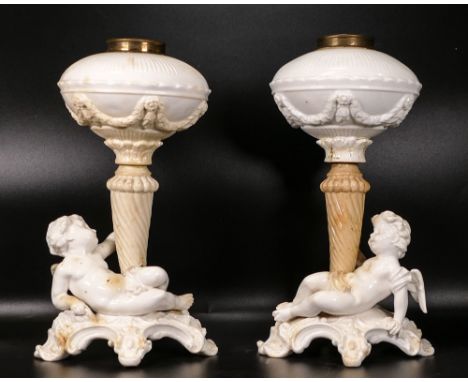 Pair of late 19th century Thomas Goode porcelain oil lamp bases, supported by two winged cherubs, restoration and hairline cr
