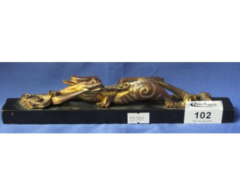 Chinese lacquered wooden scroll weight with stylised gilded dragon mount. 23cm long. *** CONDITION REPORT: General wear overa