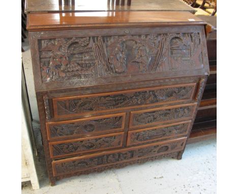 20th Century Chinese carved camphor wood bureau decorated with deeply carved designs of figures within landscapes and buildin