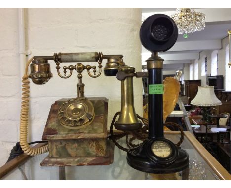 An onyx and brass dial phone with a brass and black bakelite stick phone.