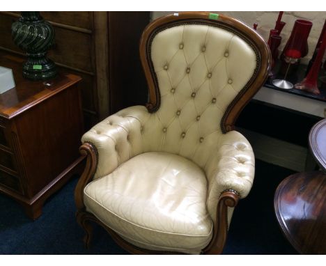 A cream leather button backed reproduction chair with mahogany frame.