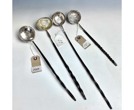 Four Georgian silver toddy ladles, the bowls set with coins, one with embossed foliate scroll decoration and set with a Georg