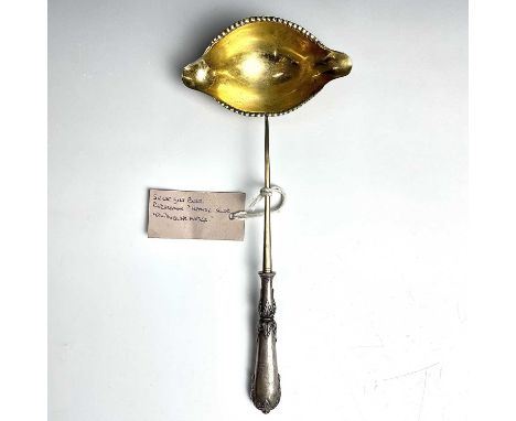 An early 19th century French silver gilt punch ladle, the bowl with double pouring lip and with a filled handle, length 27cm,
