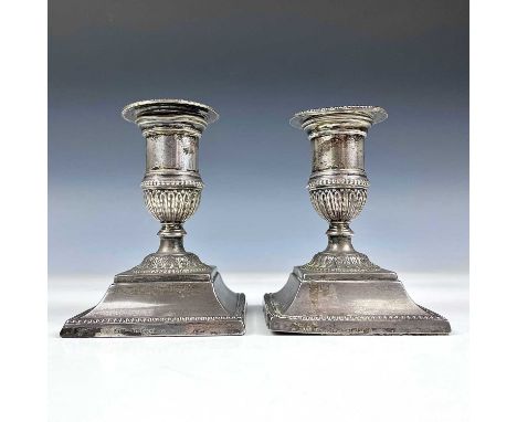 A pair of Victorian silver squat candlesticks by Horton &amp; Allday, of Neo-Classical form embossed with stiff leaves, Chest